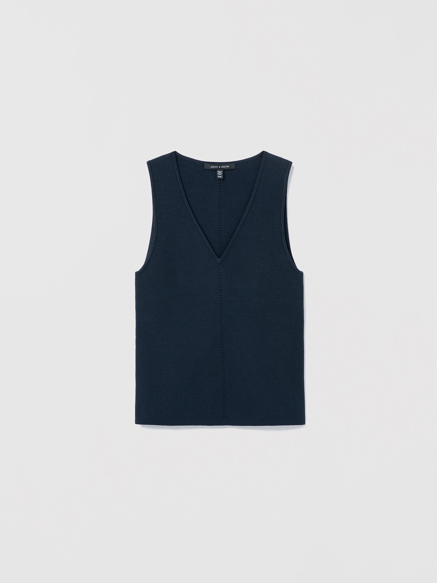 Flat‑lay of a navy V‑neck silk‑cotton shell with clean lines and minimalist finishing